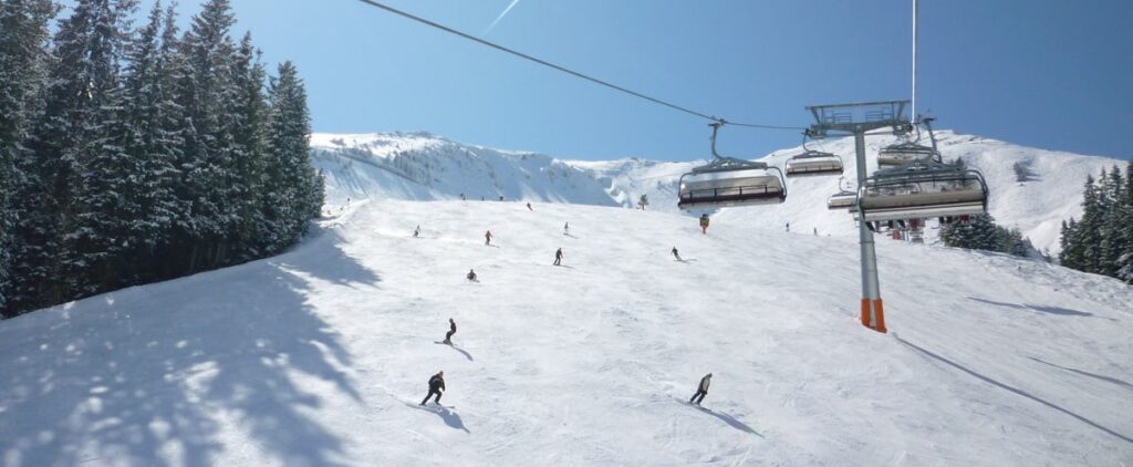 A view of skiers on a popular piste on a sunny day